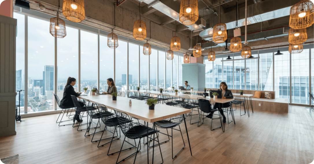 Bright open-plan coworking area with people working on laptops