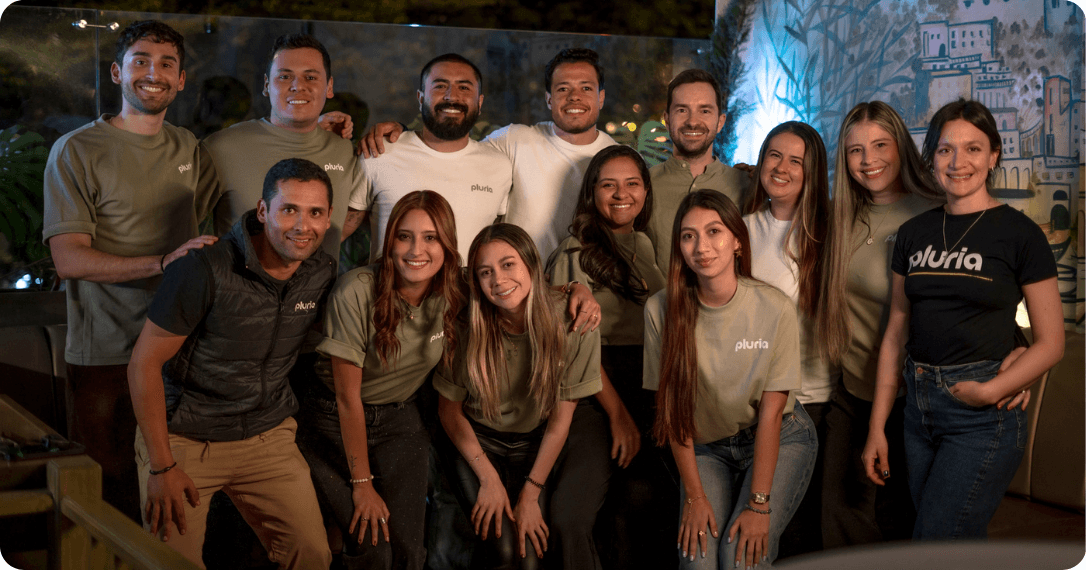Grupo de personas que componen el equipo de Pluria posando juntas para una fotografía en un evento corporativo.