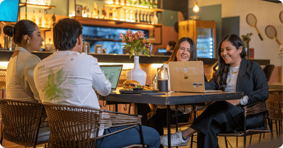 Spacious, open work café with modern design, warm lighting, and wooden tables..