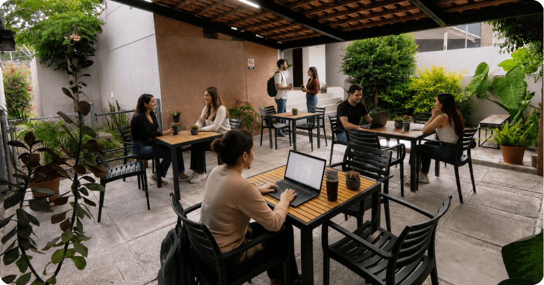 Personas trabajando de forma remota en un ambiente cómodo de work café con bebidas.